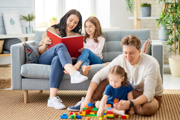 Happy family time! Two children daughters with mother and daddy. Mum, dad and girls playing at home.