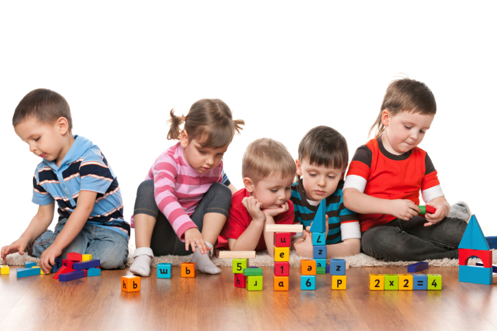 Five children are playing on the floor